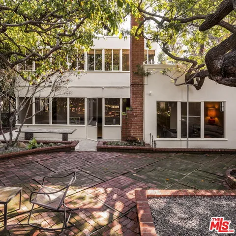 a front view of a house with a large tree and a yard