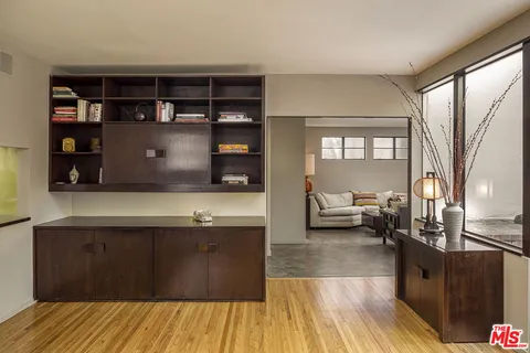 a living room with stainless steel appliances granite countertop furniture and a wooden floor