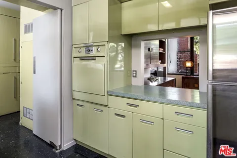 a kitchen with refrigerator and cabinets