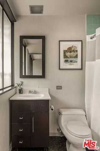a bathroom with a toilet sink and mirror