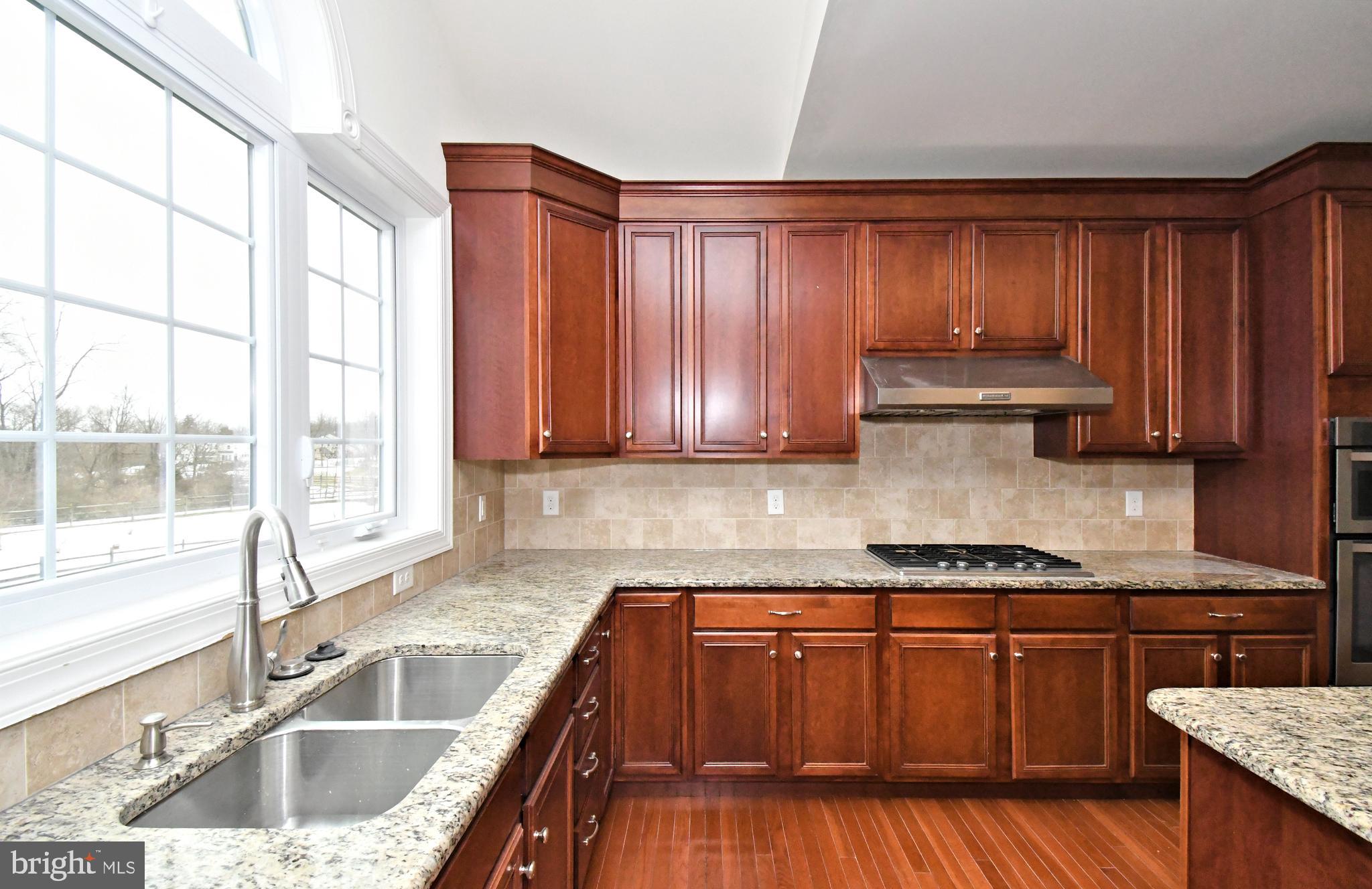 2804 Hoffs Way Warrington, PA 18976 - Photo 16 of 63 a kitchen with wooden cabinets a sink and a stove