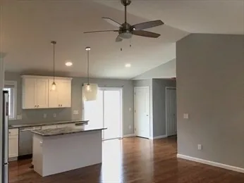 a large kitchen with granite countertop a stove a sink and a refrigerator