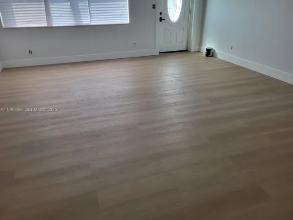 a view of a room with wooden floor