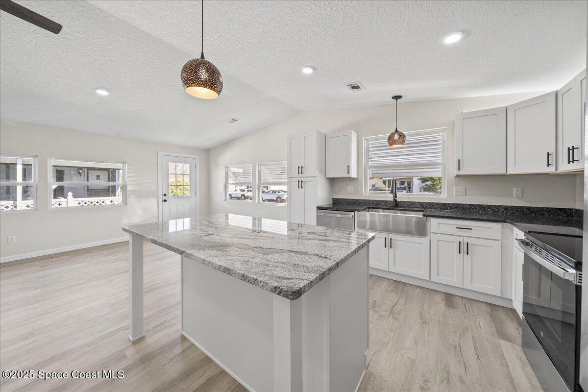 1924 Big Cypress Street Northeast Palm Bay, FL 32905 - Photo 11 of 29 a kitchen with stainless steel appliances granite countertop a sink cabinets and wooden floor