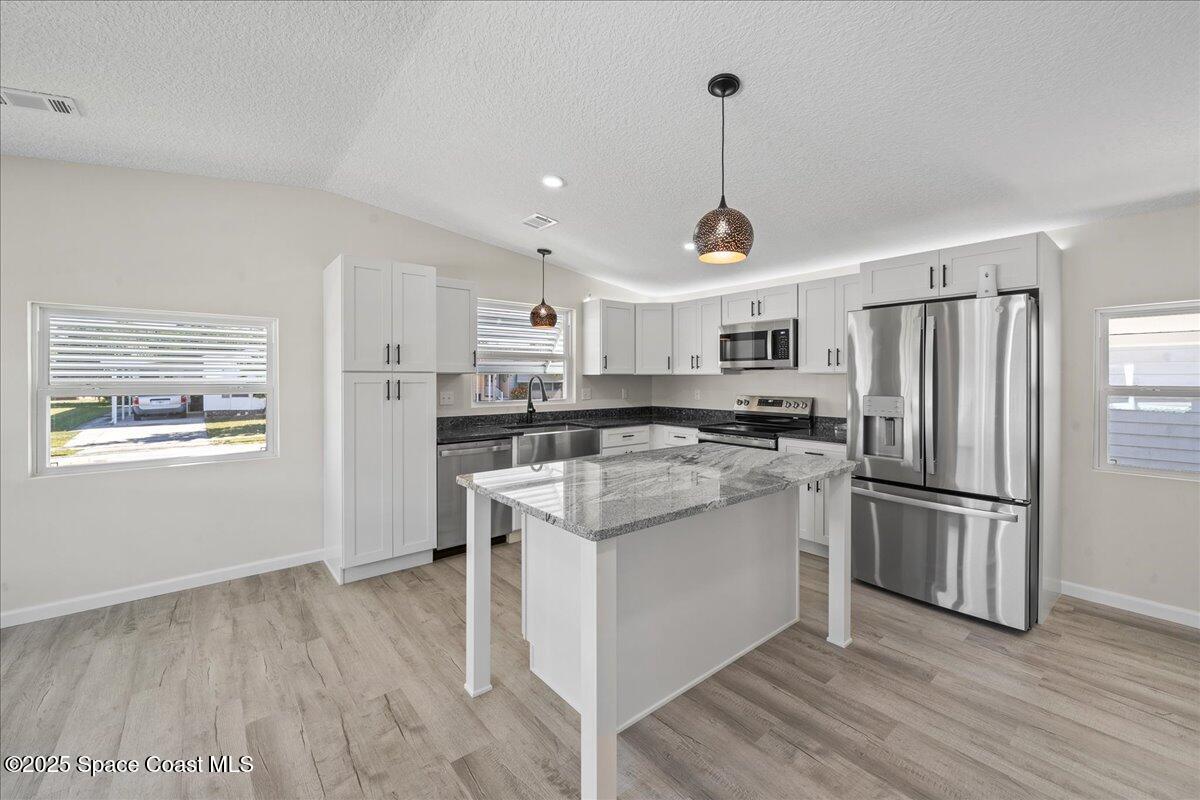 1924 Big Cypress Street Northeast Palm Bay, FL 32905 - Photo 12 of 29 a kitchen with stainless steel appliances granite countertop a refrigerator and a stove top oven