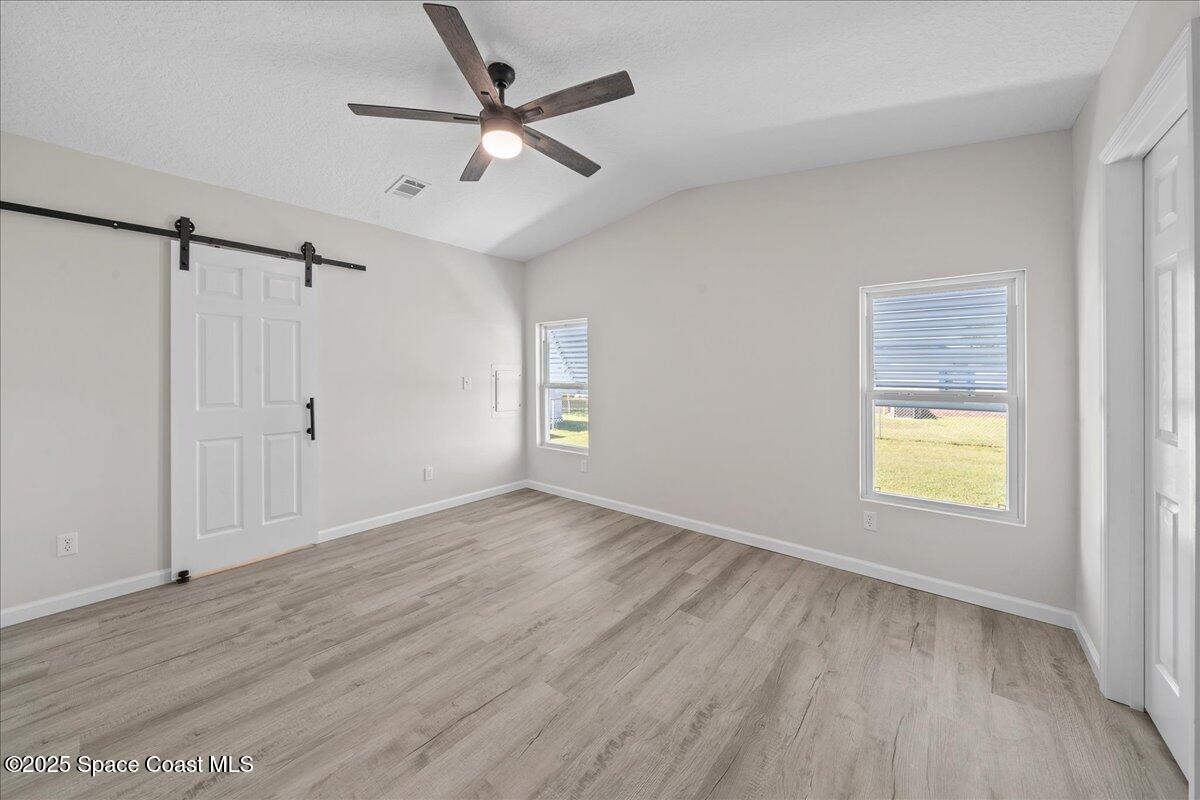 1924 Big Cypress Street Northeast Palm Bay, FL 32905 - Photo 19 of 29 a view of an empty room with a window and wooden floor