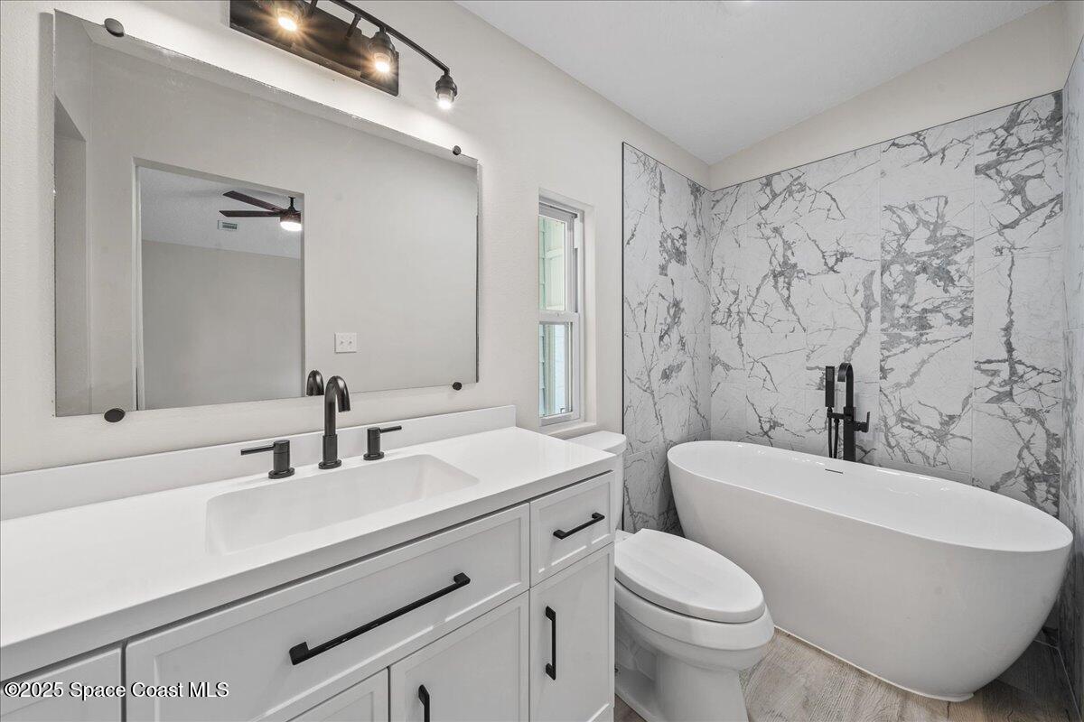 1924 Big Cypress Street Northeast Palm Bay, FL 32905 - Photo 21 of 29 a bathroom with a toilet a sink and a bathtub