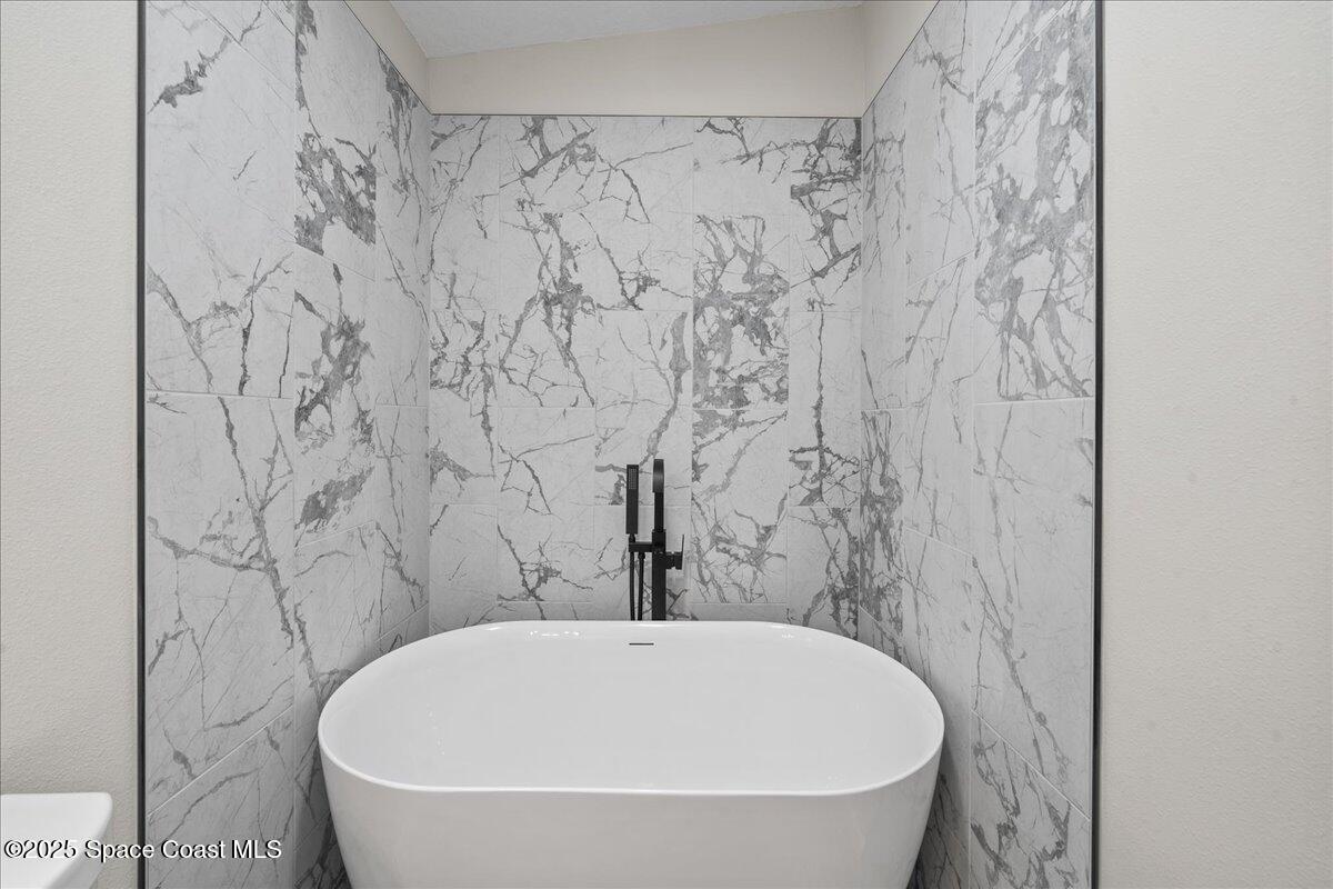 1924 Big Cypress Street Northeast Palm Bay, FL 32905 - Photo 22 of 29 a bathroom with a bathtub and shower