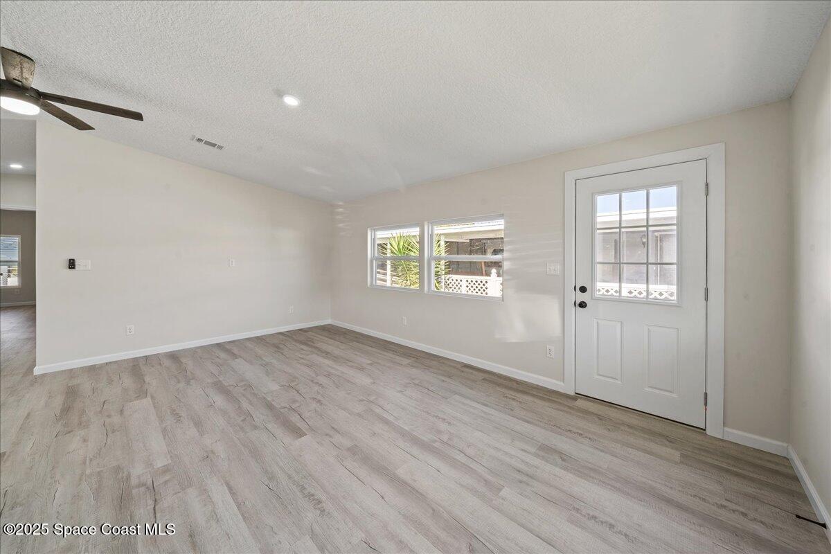 1924 Big Cypress Street Northeast Palm Bay, FL 32905 - Photo 6 of 29 an empty room with wooden floor and windows