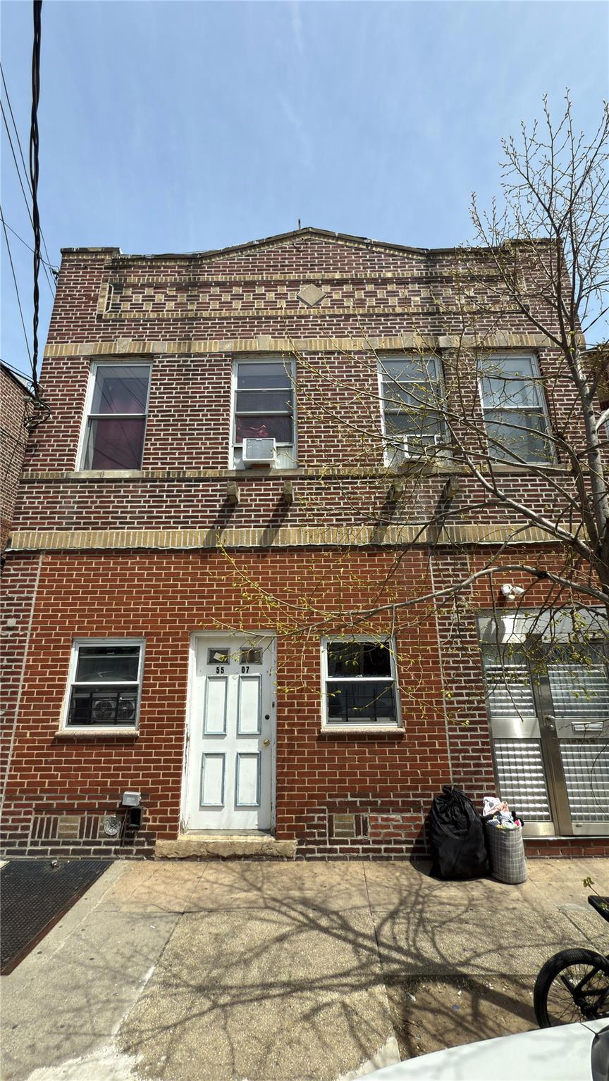 55-07 103rd Street Queens, NY 11368 - Photo 8 of 10 View of front of property featuring brick siding, cooling unit, and crawl space