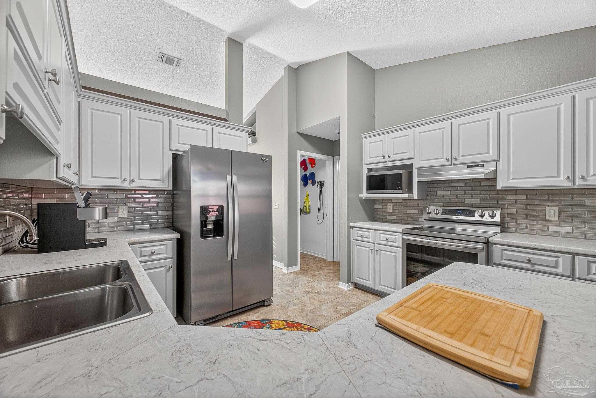 4650 Ridge Pointe Drive Pace, FL 32571 - Photo 18 of 38 a kitchen with stainless steel appliances granite countertop a refrigerator stove and sink