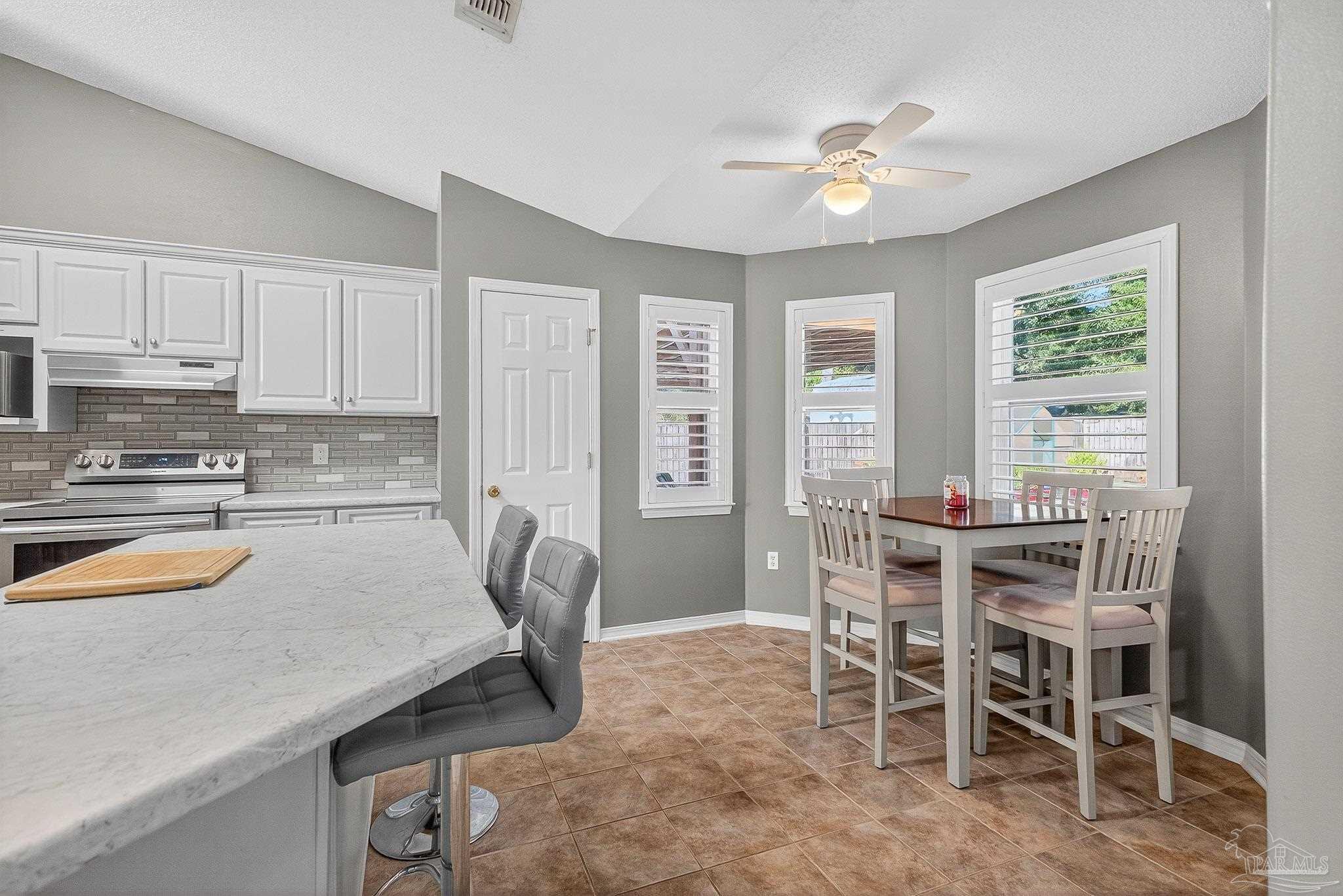 4650 Ridge Pointe Drive Pace, FL 32571 - Photo 19 of 38 a kitchen with a table chairs sink and cabinets