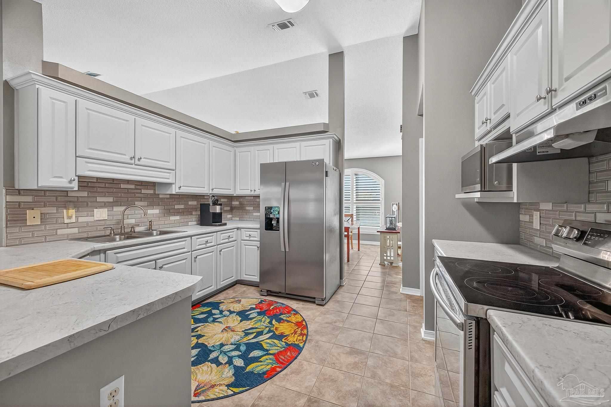 4650 Ridge Pointe Drive Pace, FL 32571 - Photo 21 of 38 a kitchen with stainless steel appliances granite countertop a refrigerator and a stove top oven