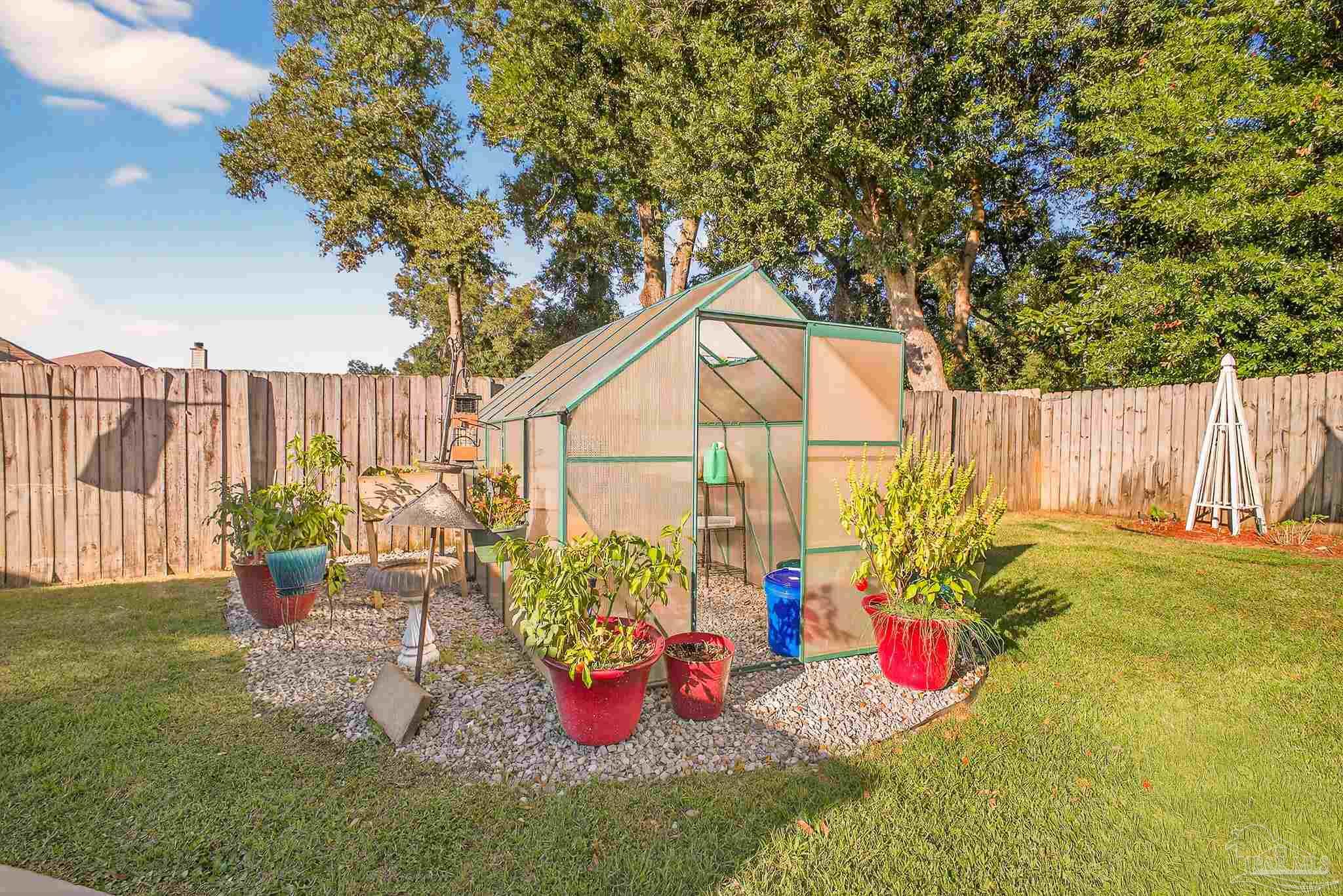 4650 Ridge Pointe Drive Pace, FL 32571 - Photo 34 of 38 a view of a backyard with plants and tree