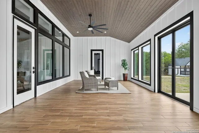 a view of an empty room with window and wooden floor