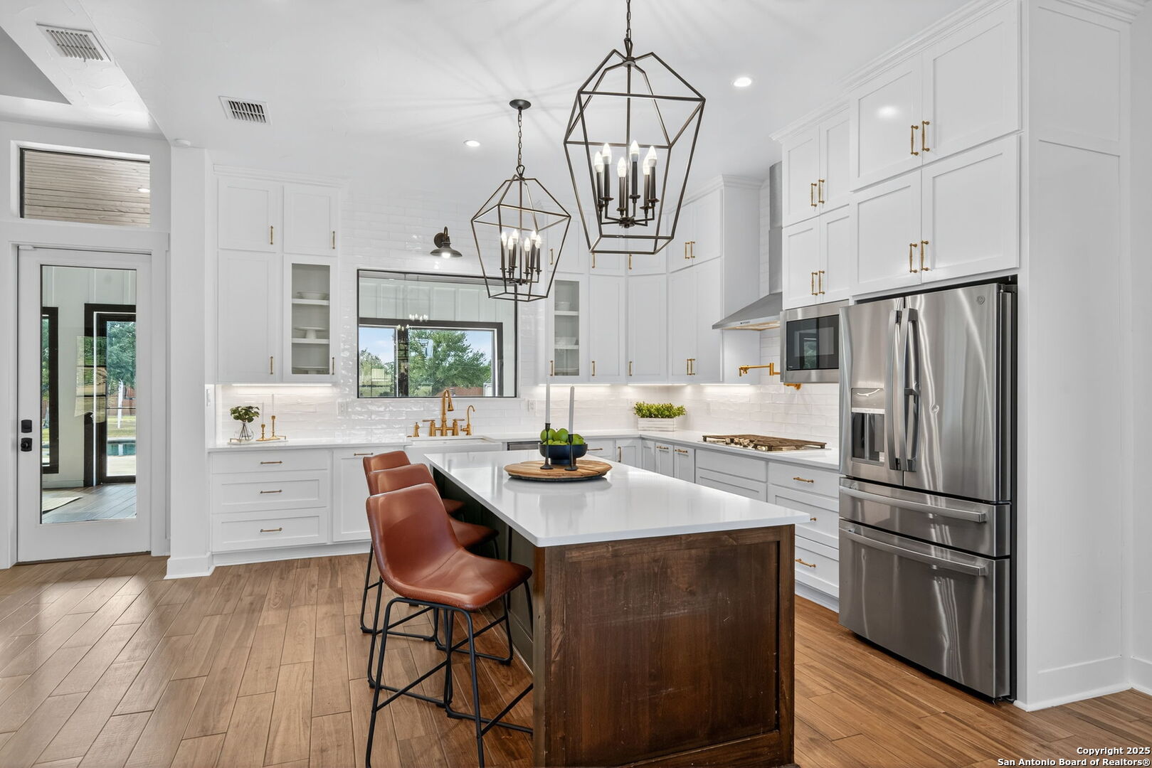 1115 Meadow Stone Court Spring Branch, TX 78070 - Photo 10 of 42 a kitchen with stainless steel appliances a dining table a sink a stove a refrigerator cabinets and wooden floor