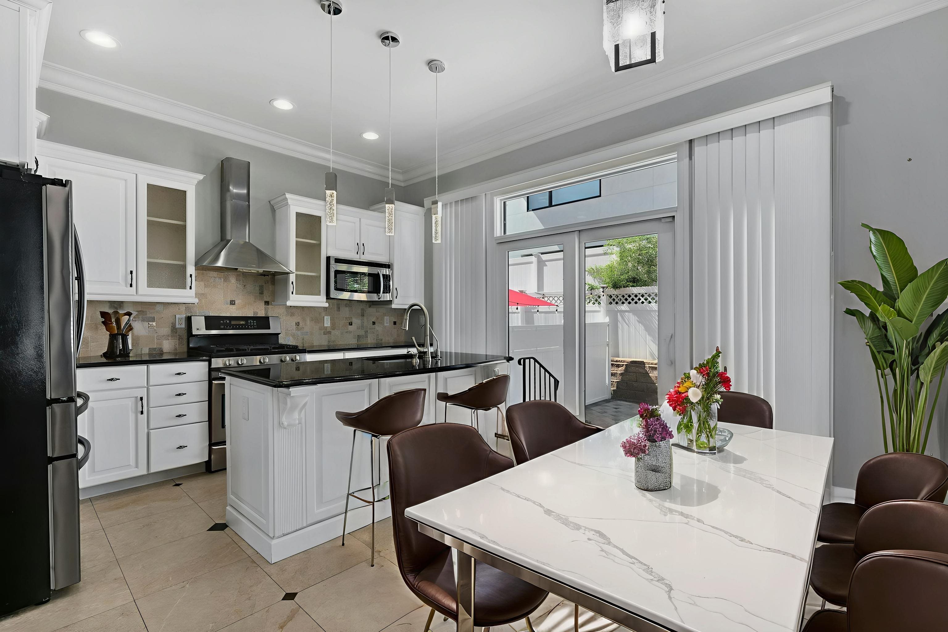 Myrtle Avenue, Unit 52B Edgewater, NJ 07020 - Photo 5 of 21 a kitchen with stainless steel appliances granite countertop a stove a refrigerator a white table and chairs