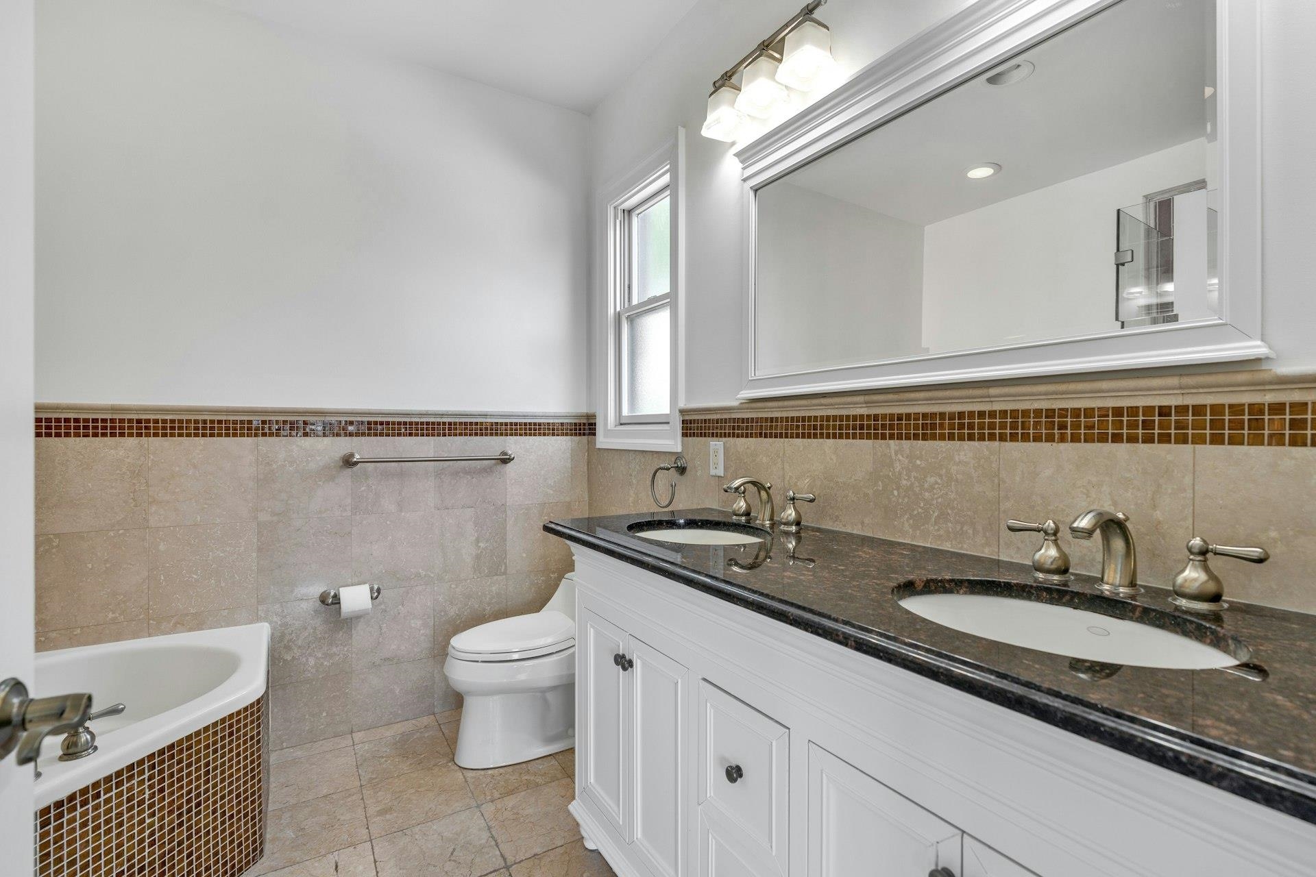 Myrtle Avenue, Unit 52B Edgewater, NJ 07020 - Photo 9 of 21 a bathroom with a granite countertop sink a toilet a mirror and bathtub