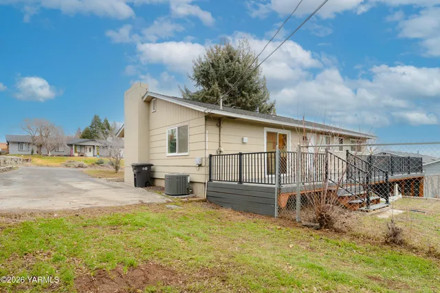 a front view of a house with a garden and lake view