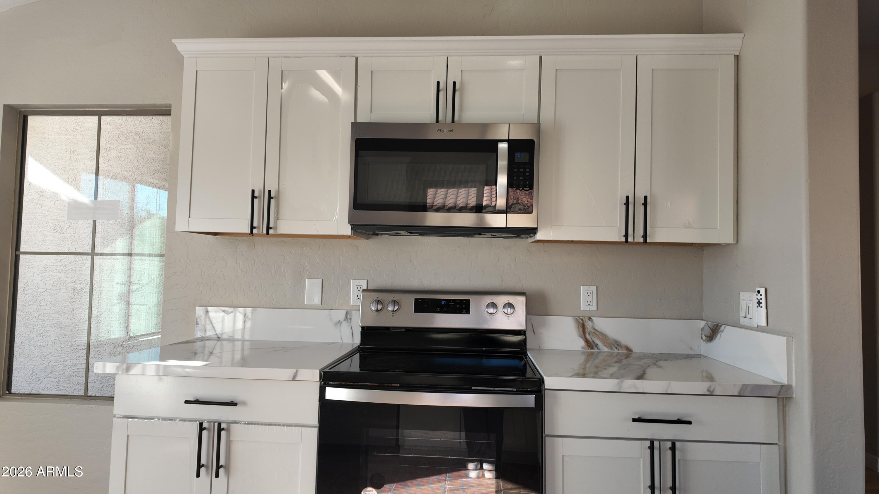 1522 East Chambers Street Phoenix, AZ 85040 - Photo 11 of 29 a kitchen with stainless steel appliances granite countertop a sink stove and cabinets