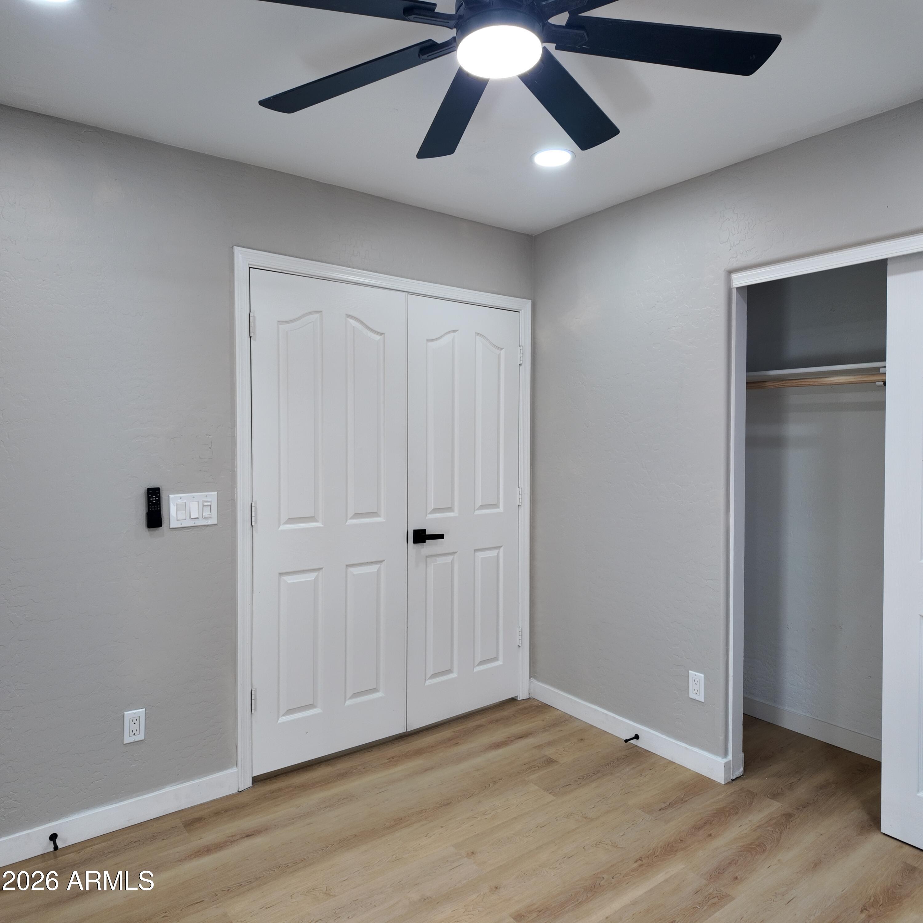 1522 East Chambers Street Phoenix, AZ 85040 - Photo 21 of 29 an empty room with wooden floor closet and ceiling fan