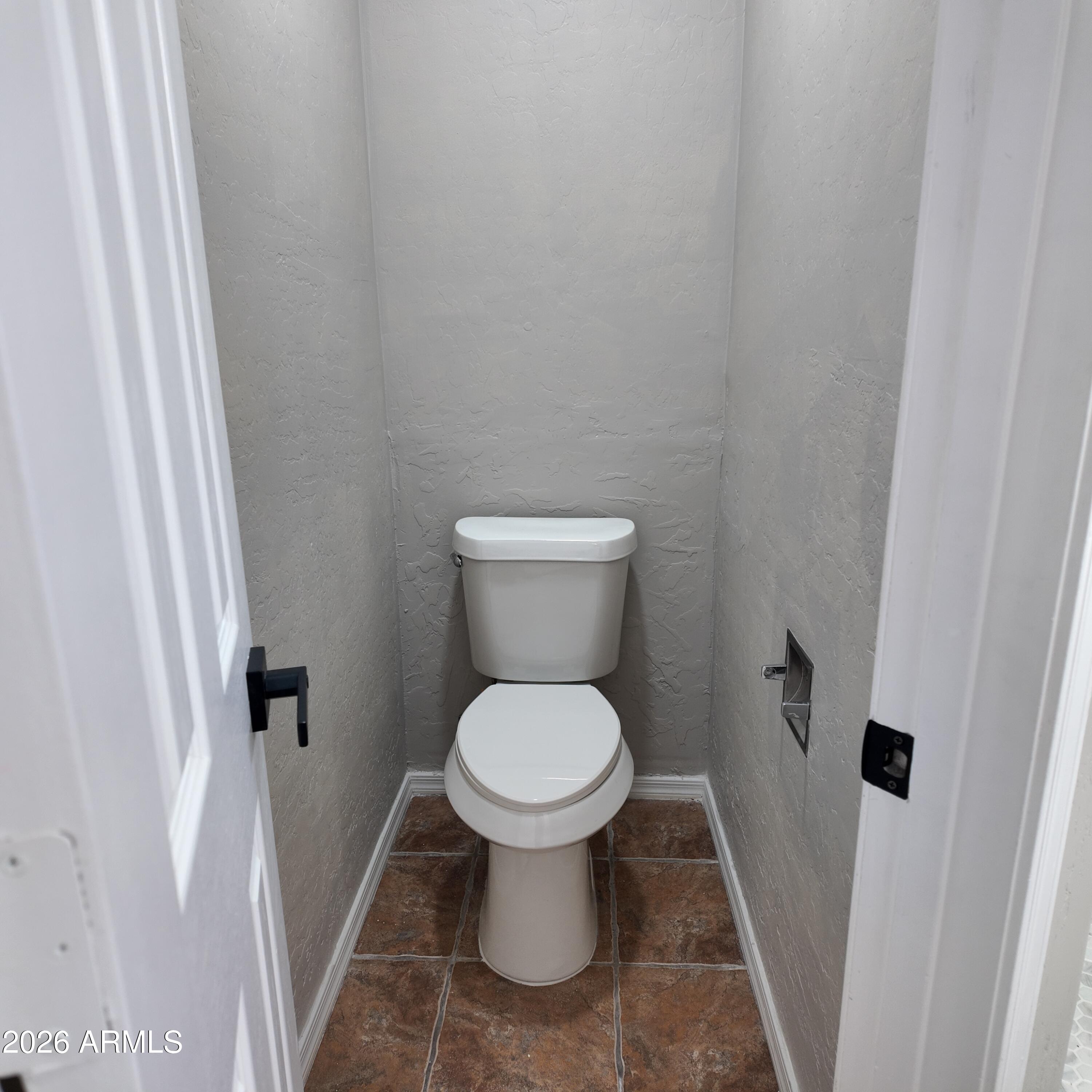 1522 East Chambers Street Phoenix, AZ 85040 - Photo 26 of 29 a white toilet sitting in a bathroom next to a sink