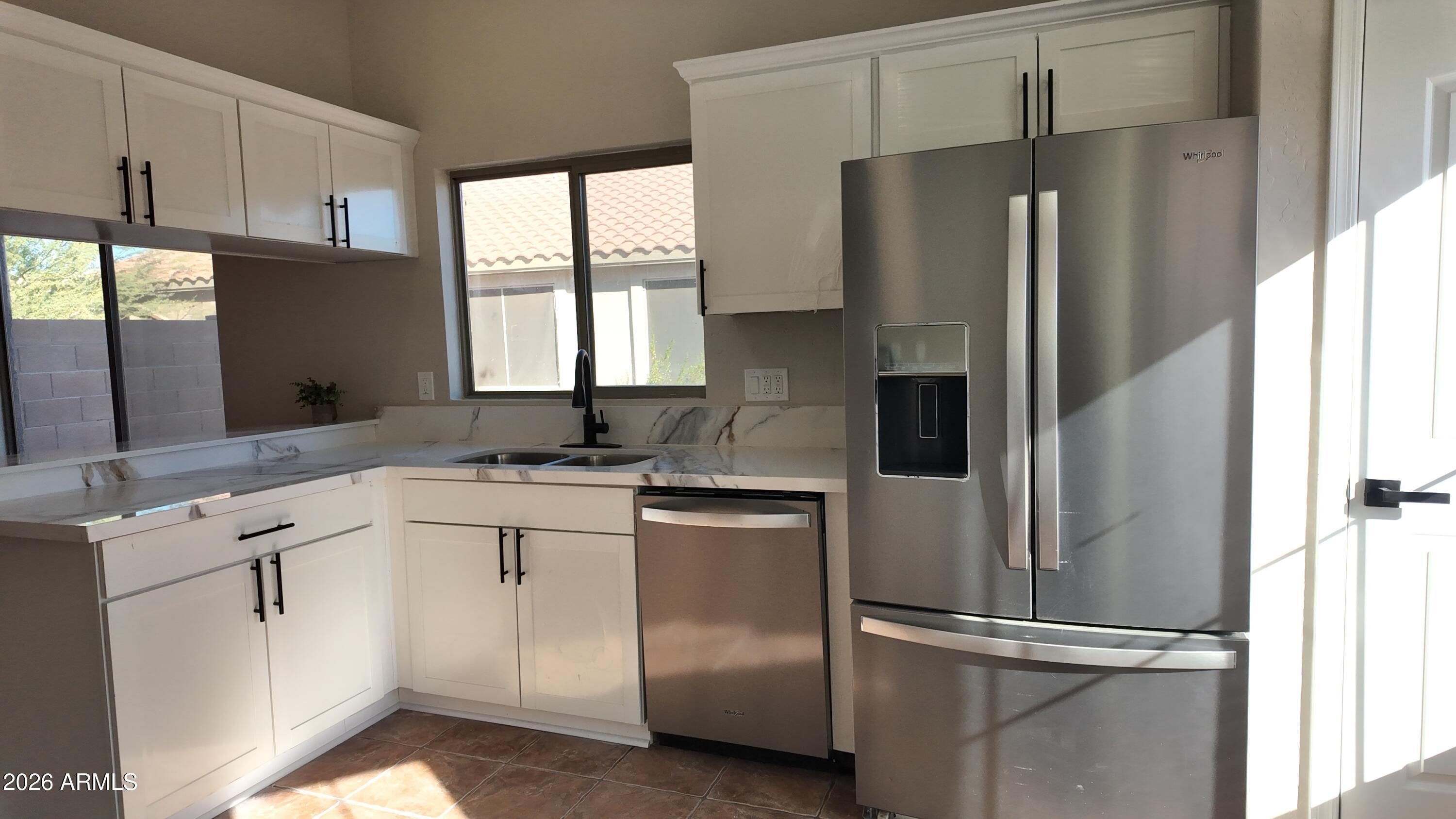 1522 East Chambers Street Phoenix, AZ 85040 - Photo 10 of 29 a kitchen with stainless steel appliances granite countertop a refrigerator sink and window