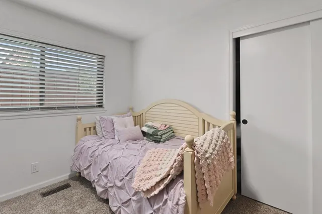 a bedroom with a bed and a window