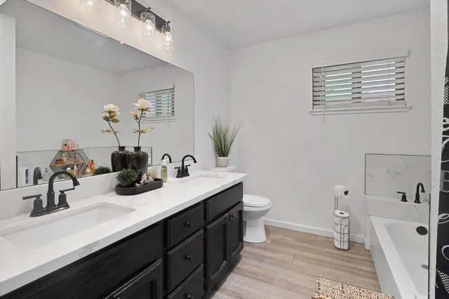 a bathroom with a double vanity sink toilet and a mirror