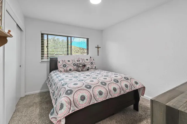 a bedroom with a bed next to a window