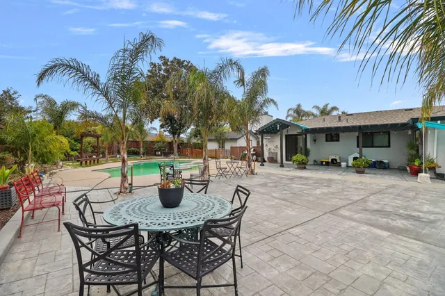 a view of a patio with couches and table and chairs and potted plants