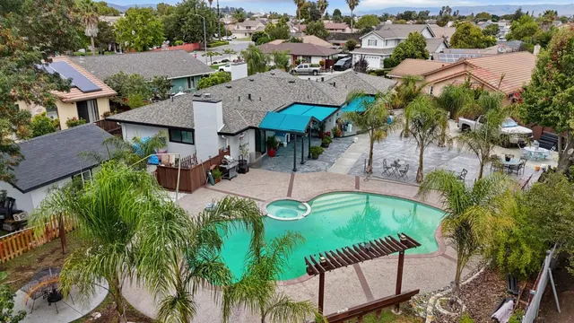 an aerial view of a house with a swimming pool and outdoor seating