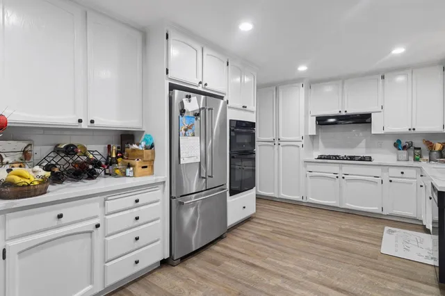 a kitchen with white cabinets and stainless steel appliances