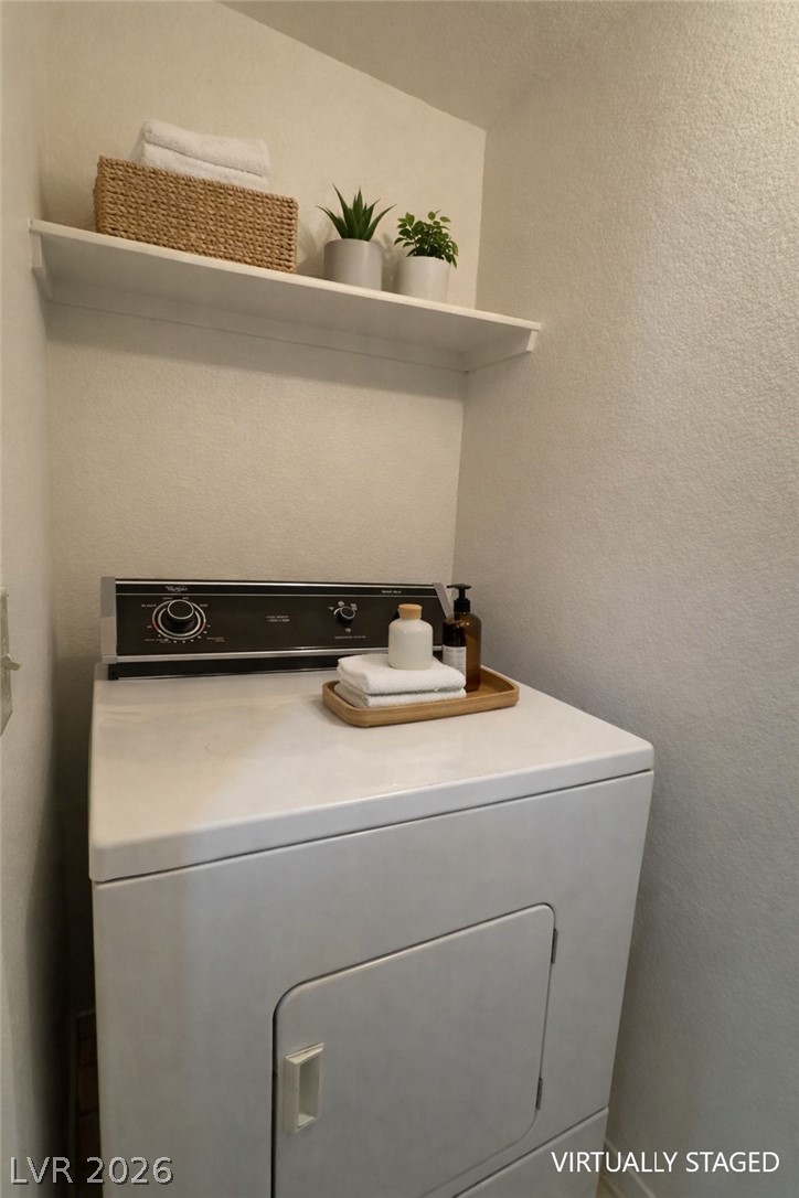 7570 West Flamingo Road, Unit 209 Las Vegas, NV 89147 - Photo 13 of 30 Laundry room featuring washer / clothes dryer and a textured wall