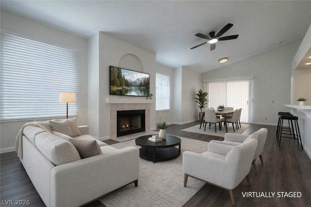 7570 West Flamingo Road, Unit 209 Las Vegas, NV 89147 - Photo 7 of 30 Living room with dark wood finished floors, a fireplace, ceiling fan, and lofted ceiling