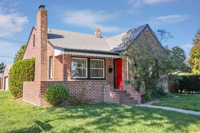 a front view of a house with a garden and plants