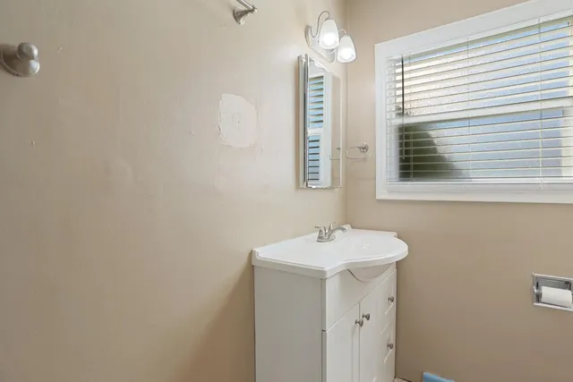 a bathroom with a sink a mirror and a window