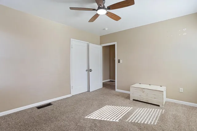 a bedroom with a bed and a ceiling fan