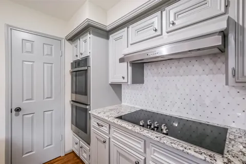 a kitchen with granite countertop a sink and a stove