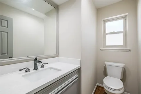 a bathroom with a sink toilet and mirror