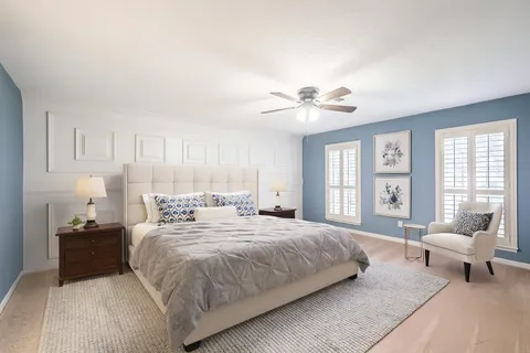 a spacious bedroom with a bed and a chandelier