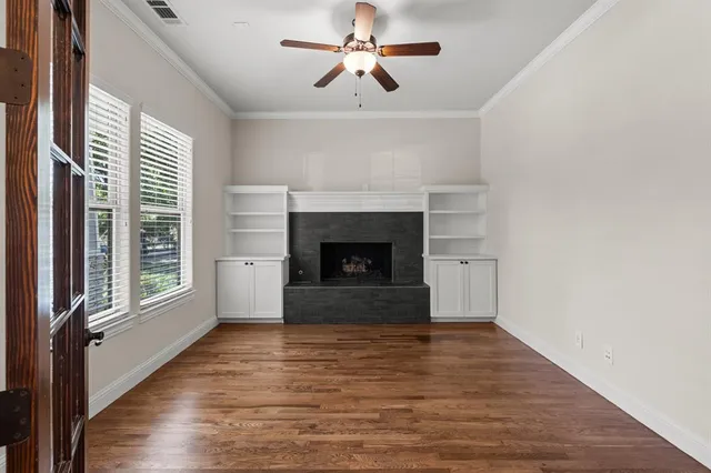 a view of empty room with fireplace and wooden floor