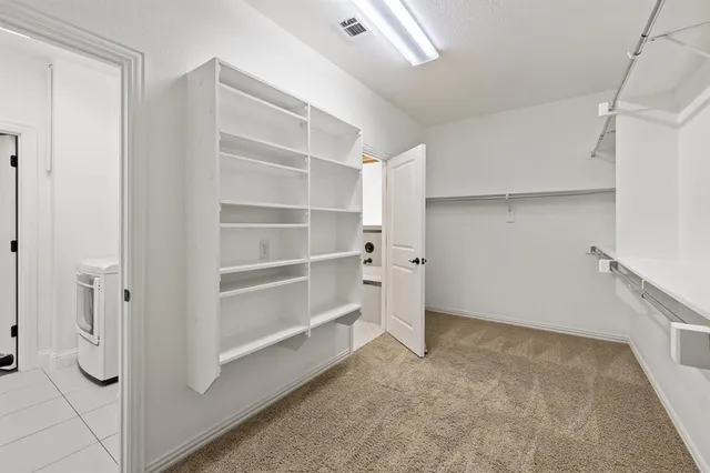 a view of walk in closet with empty racks