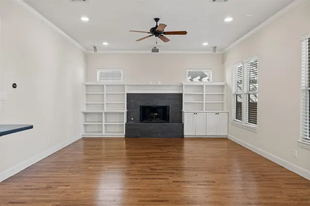 wooden floor fireplace and windows in the room