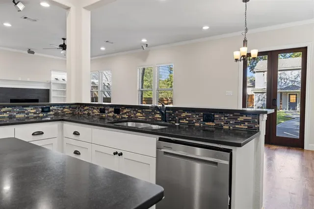 a kitchen with granite countertop a sink stove and cabinets