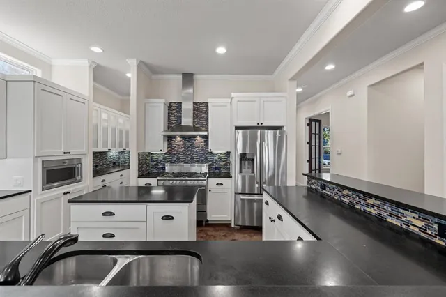 a kitchen with stainless steel appliances a sink stove and refrigerator