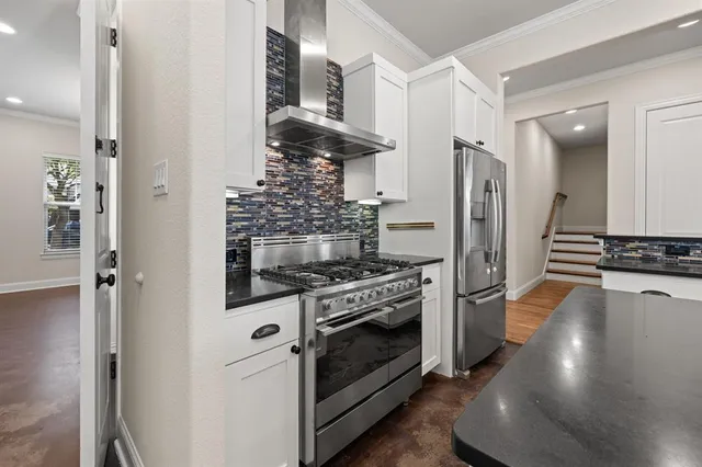 a kitchen with stainless steel appliances a stove a refrigerator and a cabinets