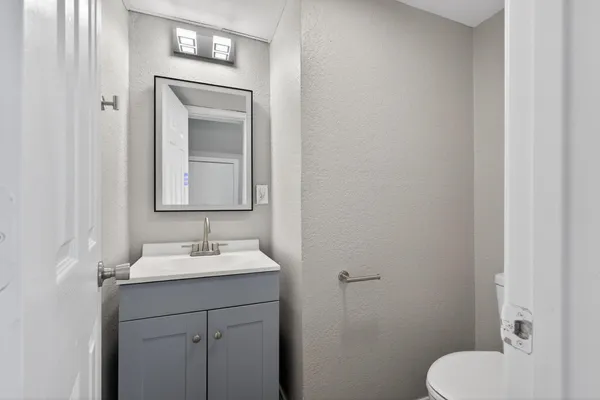 a bathroom with a toilet sink and mirror