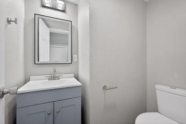 a bathroom with a toilet sink and mirror