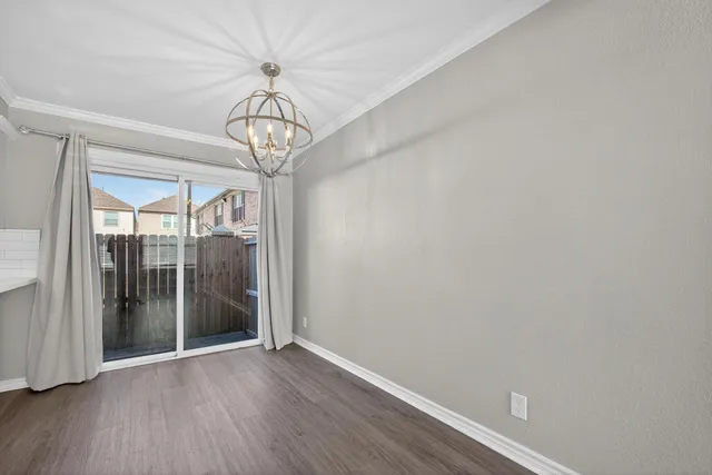 a view of a hallway with wooden floor and a chandelier